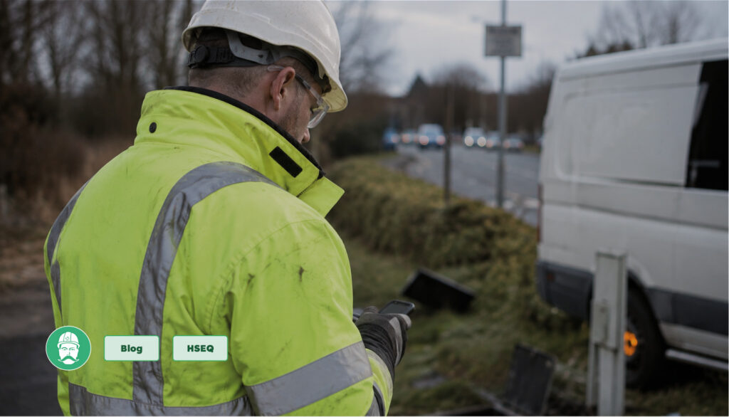 Field operative using a mobile device to record a health and safety incident during roadside utility works.