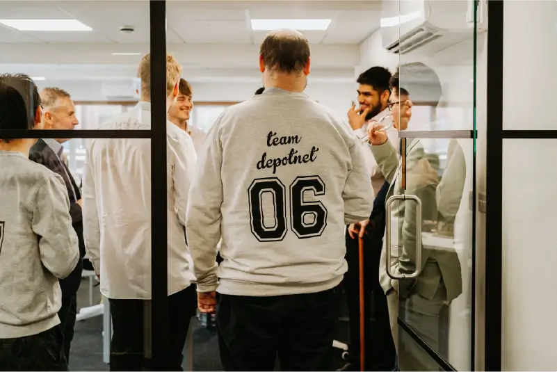 Depotnet employees gathering together in branded jumpers.