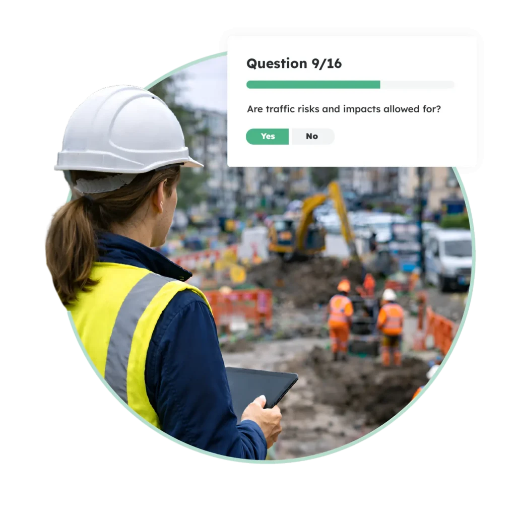Site inspector using health and safety management software to complete a risk assessment.